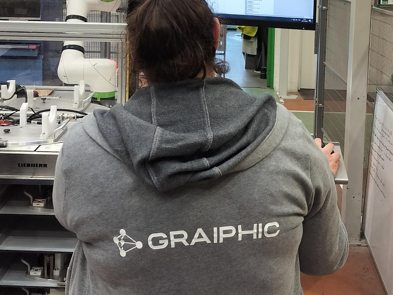 Ingénieure Graiphic devant le logiciel LabVIEW et une cellule robotisée